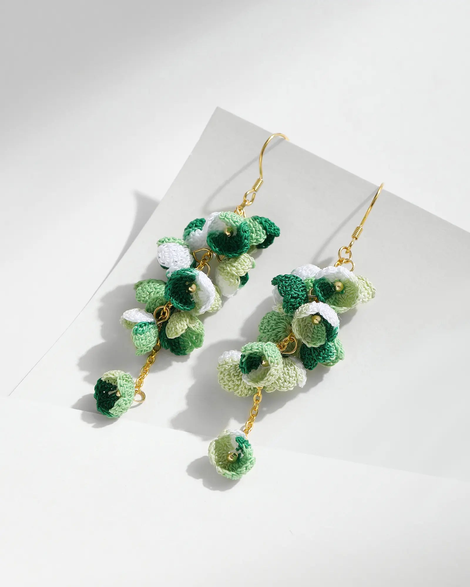 Green micro crochet Cascading Flower Drop Earrings with gold hooks on a white background