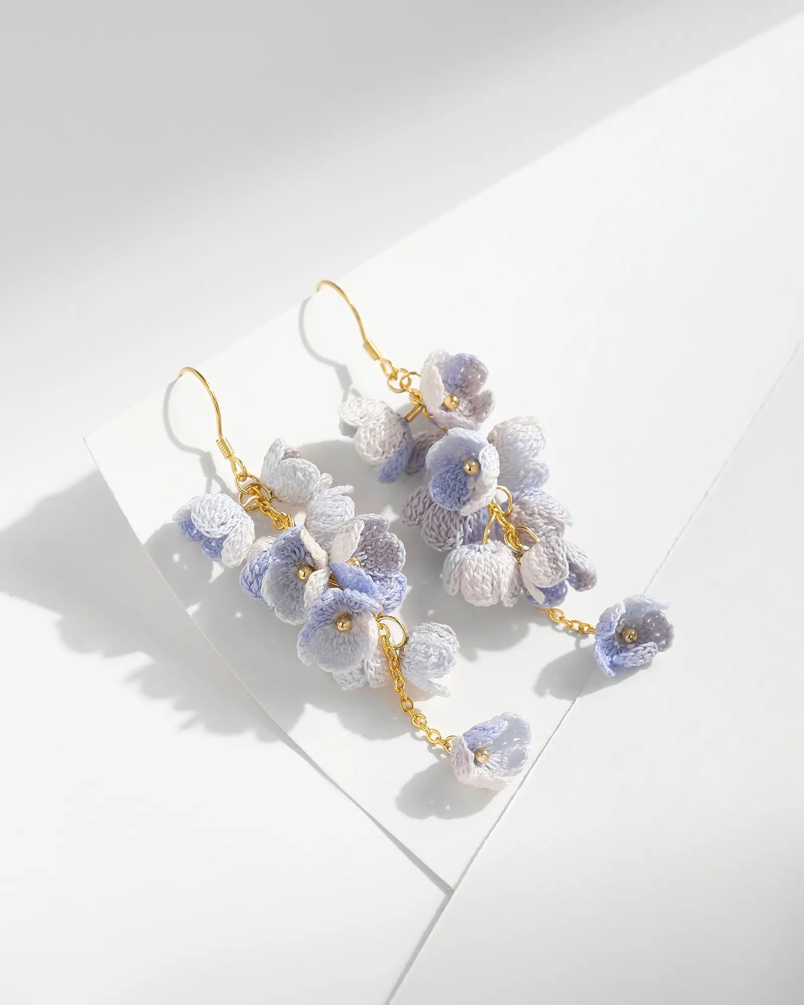 Blue micro crochet Cascading Flower Drop Earrings with gold hooks on a white background