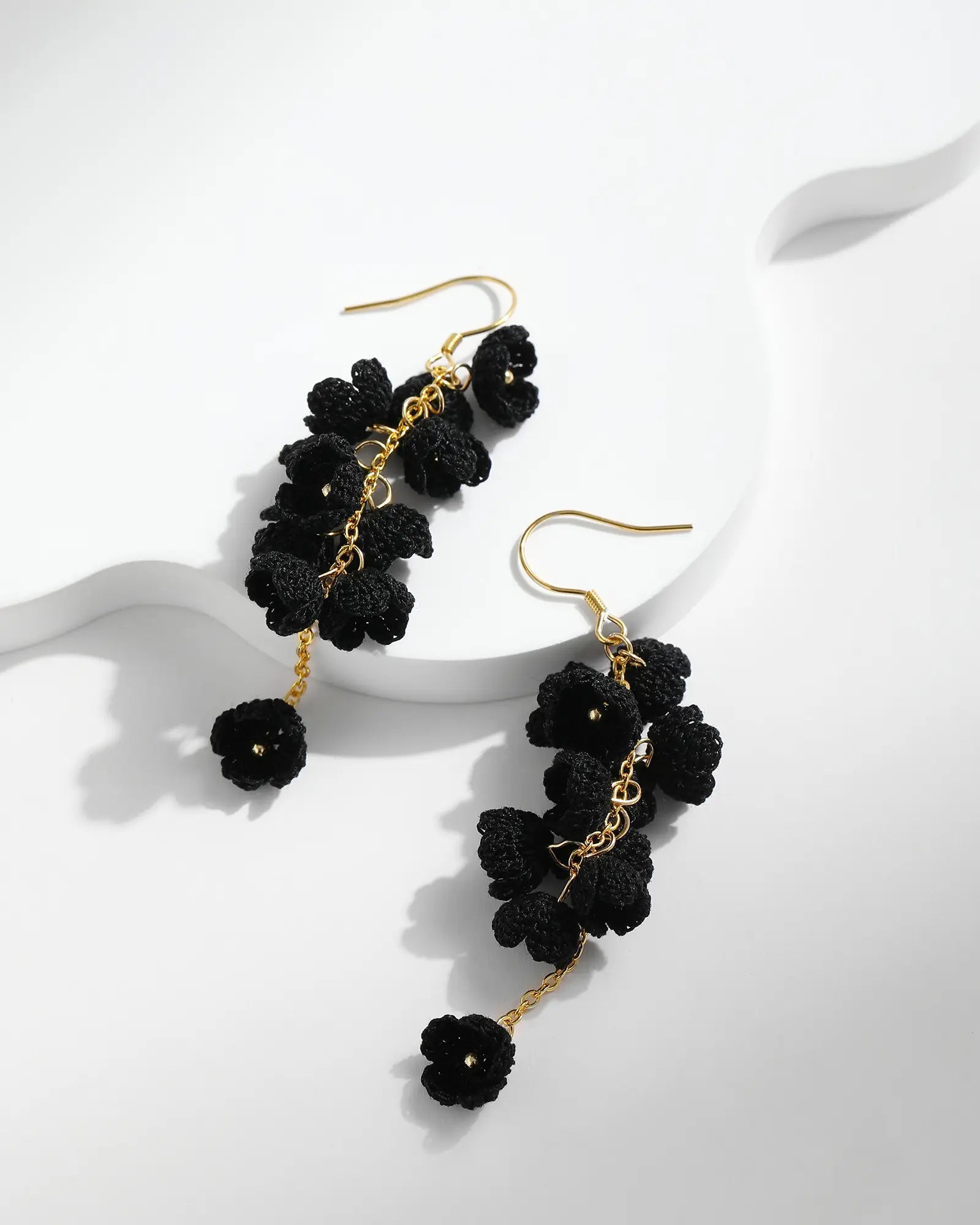Black micro crochet Cascading Flower Drop Earrings with gold hooks on a white background