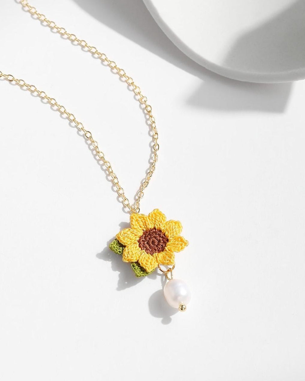 Micro crochet sunflower pendant necklace with a freshwater pearl drop on a delicate gold chain.