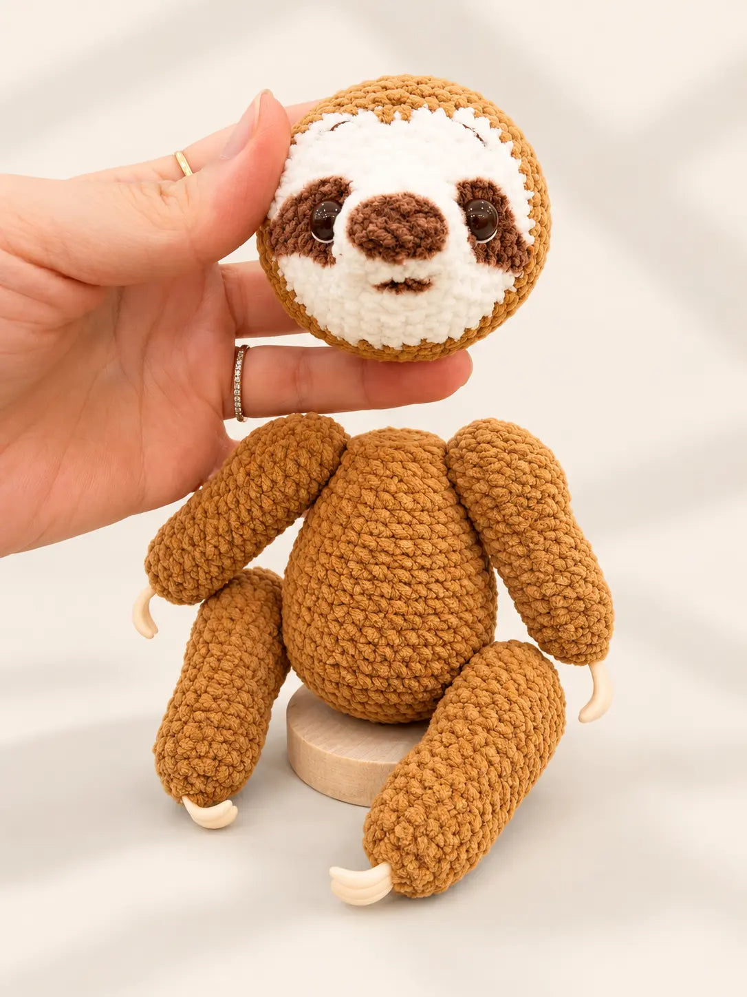 Original handmade crochet sloth ornament with detachable magnetic head, showing the separate head and body design.