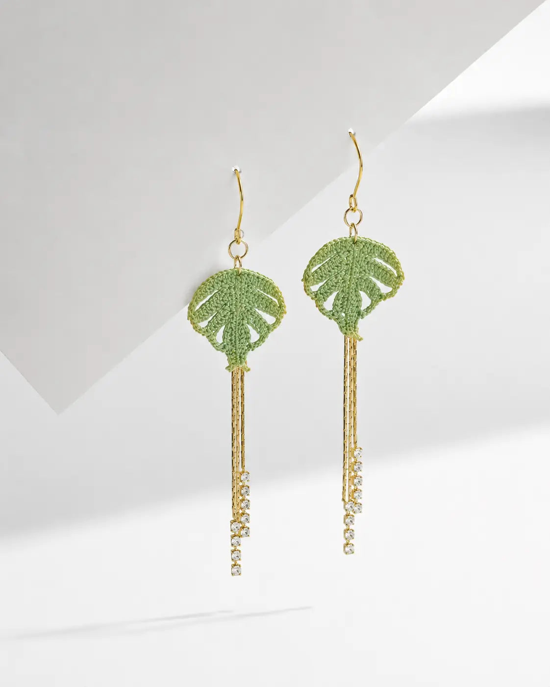 Green micro crochet Monstera Leaf & Crystal Fringe Earrings on a white background