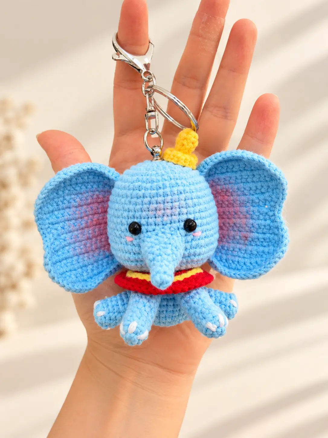 Handmade blue elephant crochet keychain and bag charm with large ears and colourful details