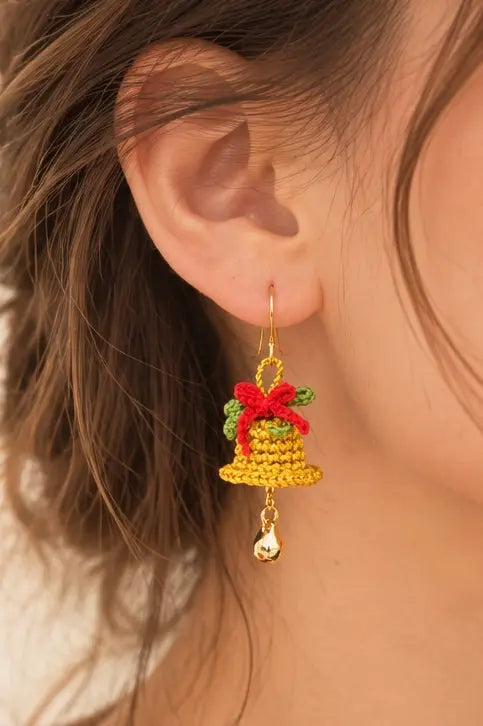 Close-up of handmade Christmas bell crochet drop earrings