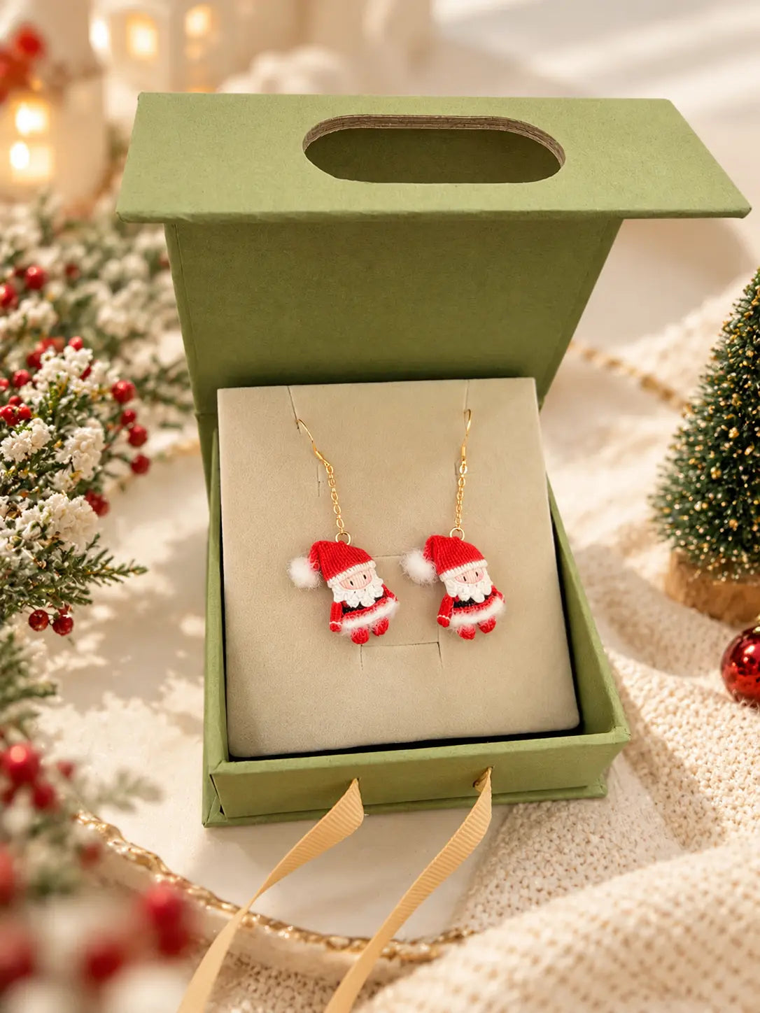 Handmade crochet Santa Claus drop earrings displayed in a green jewellery gift box with festive Christmas decorations.