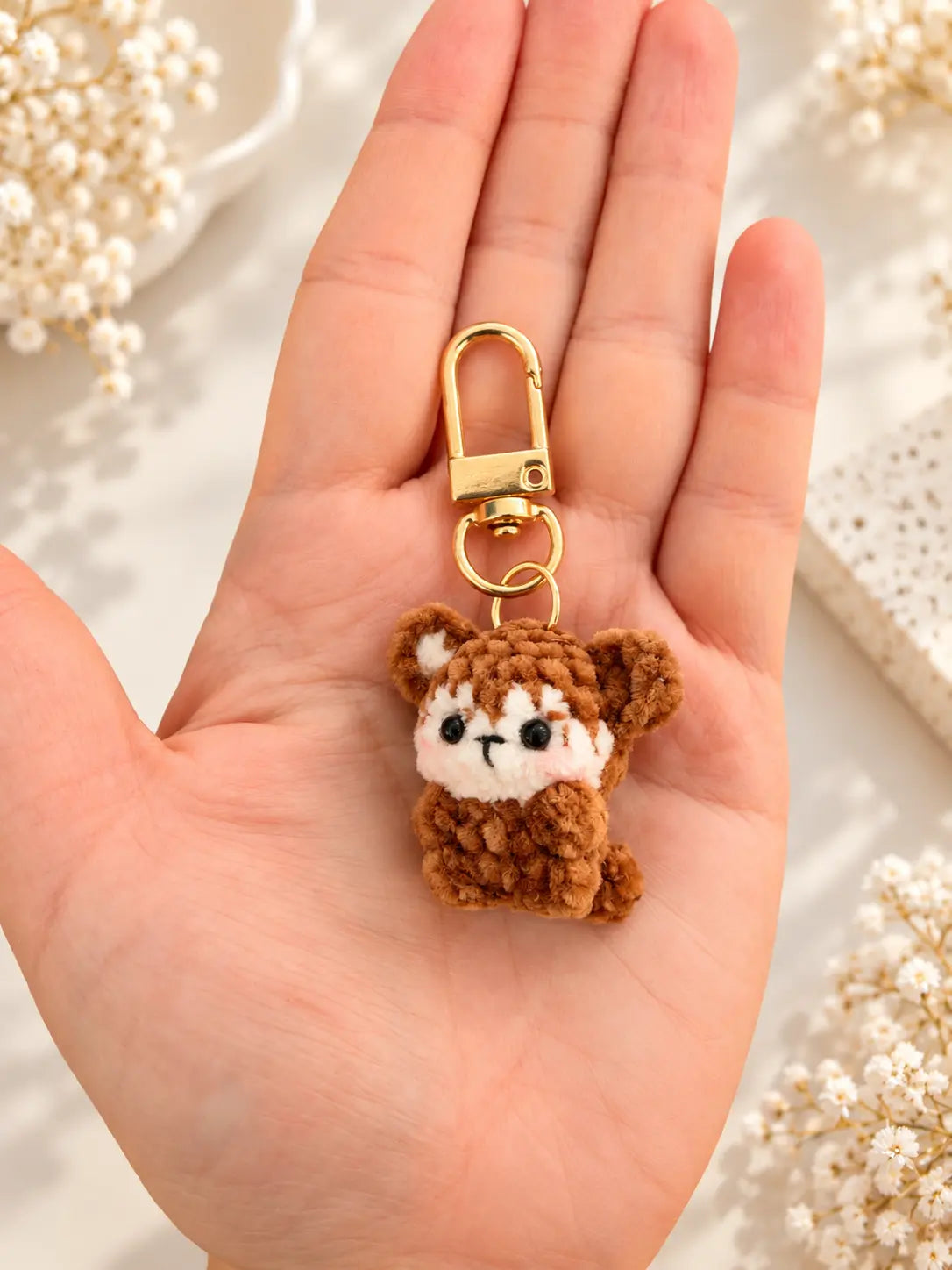 Handmade mini monkey crochet keychain and bag charm held in hand