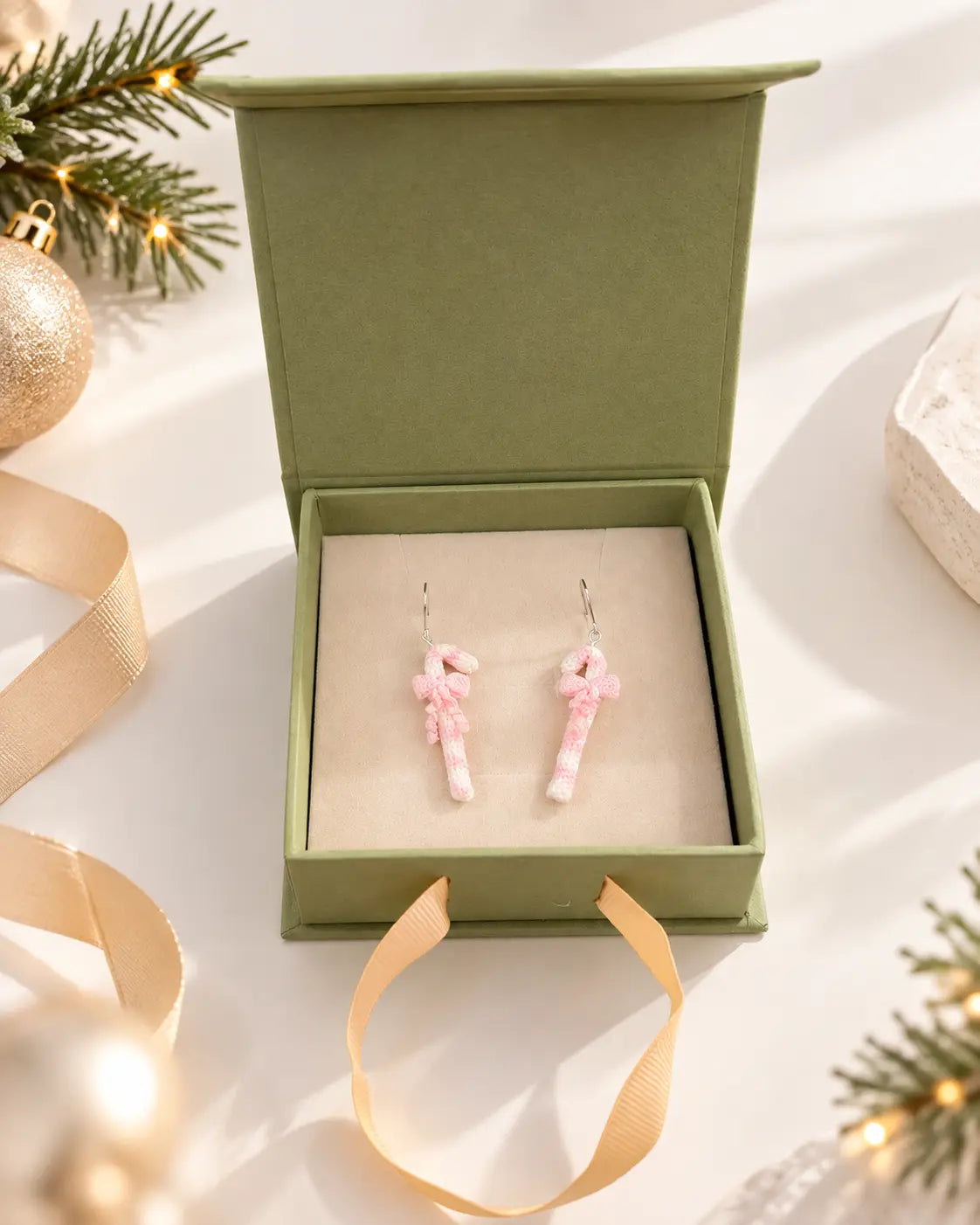 Pink candy cane Christmas earrings presented in a gift box